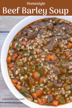 beef barley soup in a white bowl with carrots and celery on the side