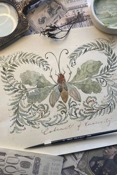 an old paper with a bug on it next to some scissors and other antique items