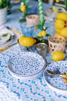 the table is set with lemons and plates