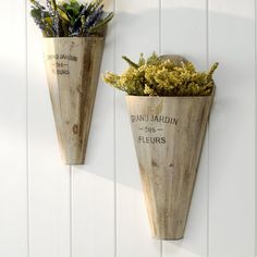 two wooden vases with plants in them on the wall, one is for sale