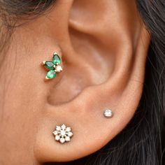 a close up of a person's ear with two different piercings on it