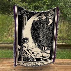 a blanket with an image of a woman sitting on a bench in front of trees