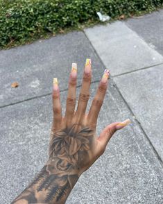 a woman's hand with yellow and white nail polish