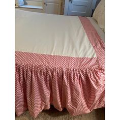 a bed with a pink and white bedspread on it