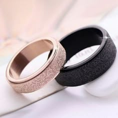 two rings with glitter on them sitting on top of a white surface next to each other