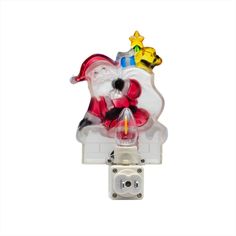 a glass christmas decoration on top of a white light switch cover with a santa clause design