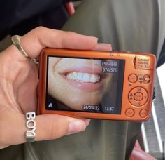 a person is holding up a camera to take a picture with their teeth on the screen