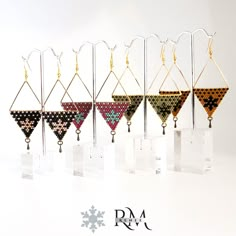 a row of earrings on display in front of a white background with snowflakes