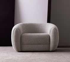 a grey chair sitting on top of a carpeted floor