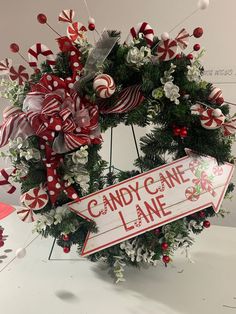 a christmas wreath with candy cane lane sign