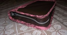 a pink and brown purse sitting on top of a bed