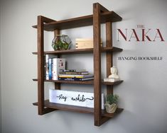 a wooden shelf with books and other items on it in front of the naka logo