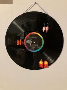 a record hanging on the wall with earring clips attached to it's side