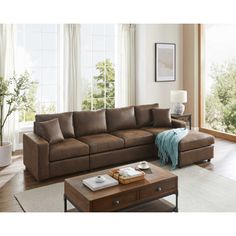 a living room with a brown couch and coffee table in front of a large window