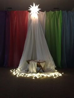 a room with curtains and lights on the floor, in front of a curtained wall