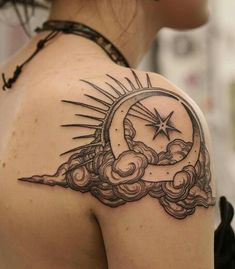 a woman's back with a tattoo on her shoulder and the moon in the sky