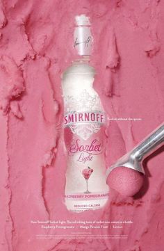 a bottle of smirnoff on a pink background with a scoop of powder next to it