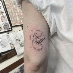 a small cat tattoo on the arm