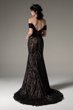 a woman in an off the shoulder black lace dress with her back turned to the camera