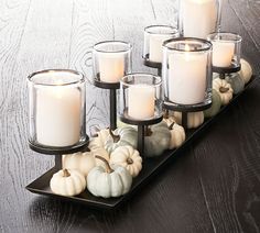 candles and pumpkins are arranged on a tray