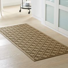 a beige rug on the floor in a white room