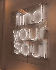 a neon sign that says find your soul on the side of a wall in a room