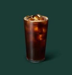 a tall glass filled with ice and cola