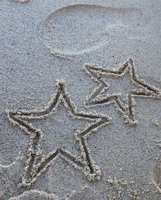 two stars drawn in the sand on a beach