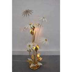 a vase filled with lots of white flowers on top of a table next to a wall