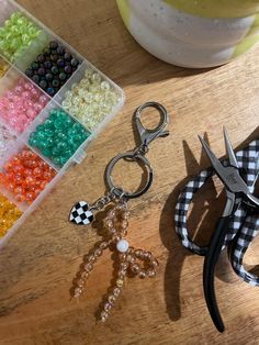 scissors and beads are sitting on a table next to a container with some scissors in it