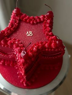 a red cake with an embroidered heart on top