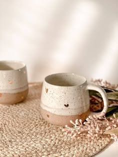 two coffee mugs sitting on top of a placemat