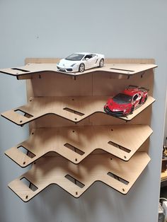 two toy cars are on top of wooden shelves