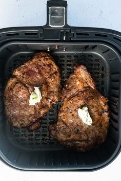 two steaks are being cooked in an air fryer