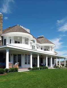 a large white house sitting on top of a lush green field