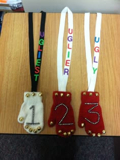 three pairs of gloves with numbers on them sitting on a wooden table next to each other