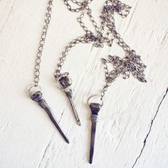 Unconventional yet striking, this relic antique coffin nail necklace exudes a mystical aura and playful witchy charm! The vintage coffin nail, salvaged from old wooden boards and/or rescued horse shoes (not real coffins!), is believed to ward off negativity, ill will, and malicious intentions. Hand-forged by skilled Blacksmiths, these nails are fittingly called coffin nails due to their square iron shape. Choose your style wisely! The nail can be adorned with copper, natural brass, pewter or sil Nail Necklace, Nails Necklace, Vintage Nails, Horse Shoes, Wooden Boards, Copper Chain, Jewelry Cleaner, Hand Forged, Coffin Nails