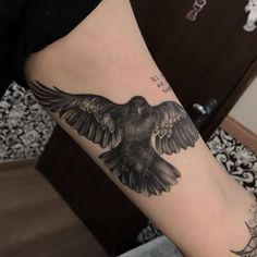 a black and white bird tattoo on the arm