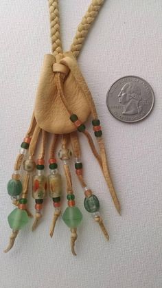 a coin is sitting next to a necklace made from beads and other things that are on display