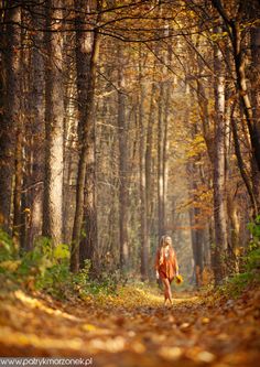 a woman running through the woods in autumn