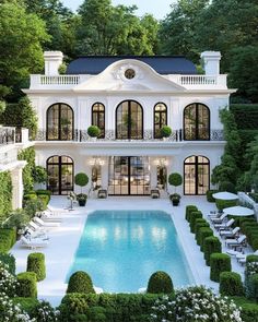 an aerial view of a large white house with a swimming pool