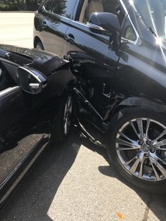 two cars that have been involved in an accident, one is black and the other is silver