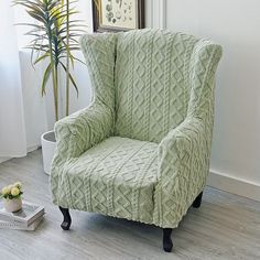 a green chair sitting next to a plant in a living room