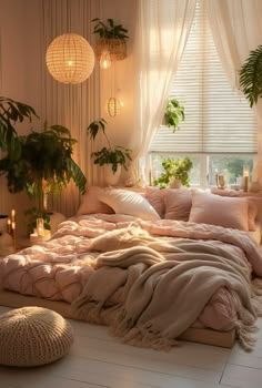 a bed with pink sheets and pillows in a room filled with plants on the windowsill