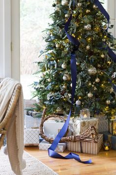 a decorated christmas tree with blue ribbon