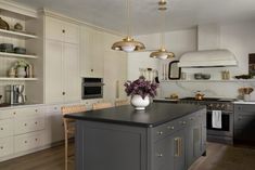 a large kitchen with an island in the middle and lots of cabinets on both sides