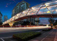 an illuminated pedestrian bridge over a city street