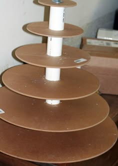 a stack of brown plates sitting on top of a wooden table