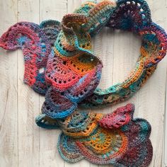 multicolored crocheted scarf on wooden surface