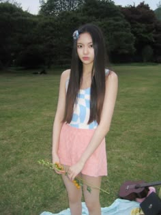 a young woman standing on top of a grass covered field